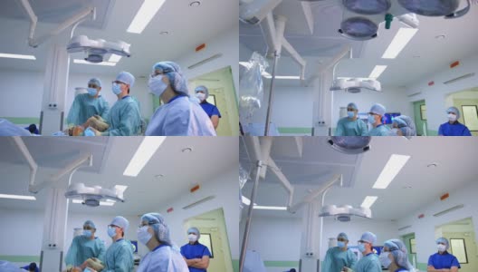 外科医生的联合工作。在现代医疗室背景下，一群医生在给病人做手术时直视着病人。卫生保健的概念。高清在线视频素材下载