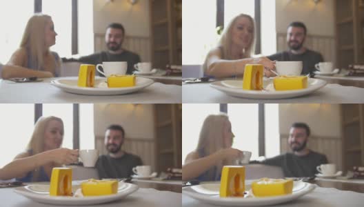 甜蜜的甜点面前的情侣坐在咖啡馆享受咖啡和大笑高清在线视频素材下载