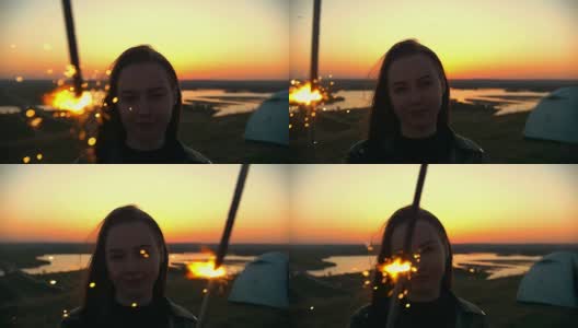 一个年轻女子的肖像与闪光站在一个小山在夏季日落高清在线视频素材下载