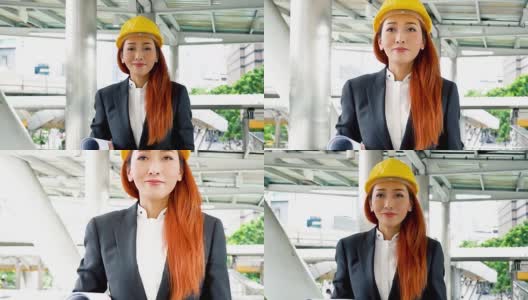 年轻貌美的亚洲工程师，穿着西装，戴着安全帽，走在办公楼的通道上高清在线视频素材下载