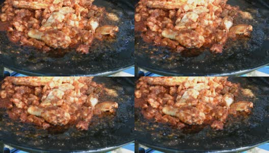 西班牙海鲜饭的制作过程，在大平底煎锅中，用番茄沙司和滚烫的橄榄油煎炸鸡肉兔肉高清在线视频素材下载