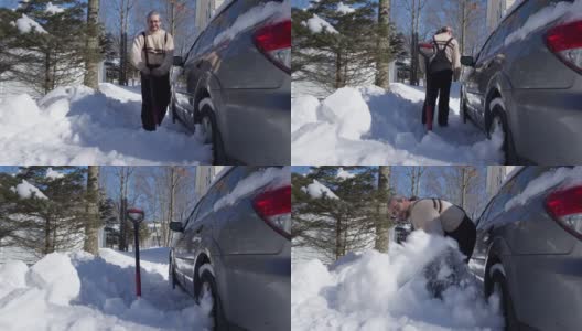 一个阳光明媚的冬日，一名50岁的白人男子正在用铲子清理他停在车道上的车，他的车被大雪覆盖。高清在线视频素材下载