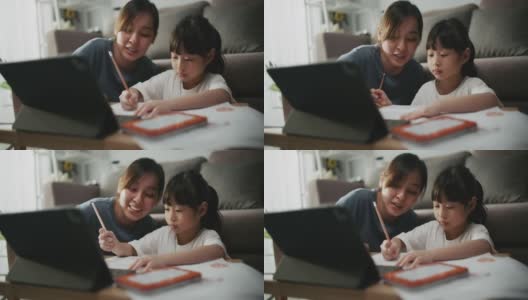 母亲帮助女儿使用笔记本电脑进行家庭教育高清在线视频素材下载