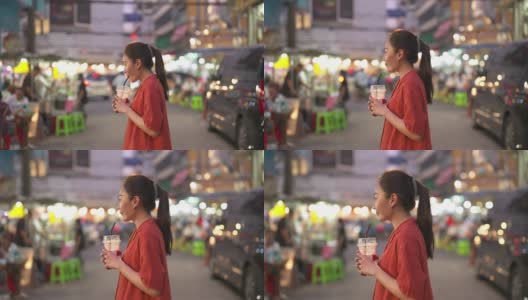 4K亚洲妇女购物和喝果汁，走在街头夜市高清在线视频素材下载