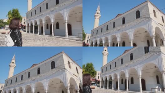 年轻的女游客来文化度假。Alacati Pazaryeri清真寺，始建于1874年，位于土耳其伊兹密尔省的Alacati度假小镇高清在线视频素材下载