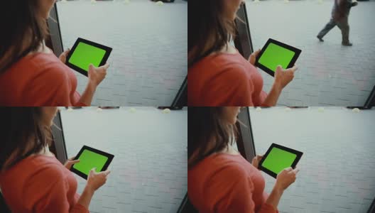 一个女人在窗前用平板电脑。绿屏高清在线视频素材下载