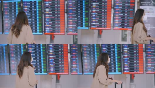 旅客在机场戴着口罩看航班时刻表。高清在线视频素材下载
