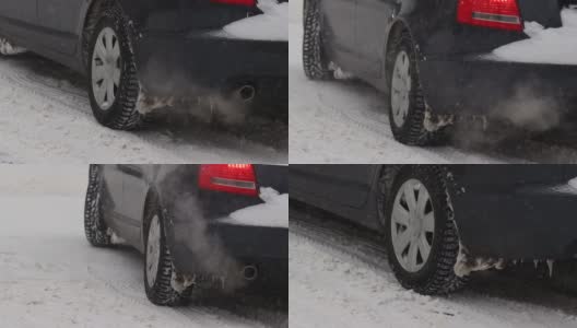 汽车正行驶在冬季城市里积雪覆盖的道路上。排气管中冒出的烟雾。降雪。车轮的慢动作特写。轮胎面。交通状况不佳，暴风雪高清在线视频素材下载