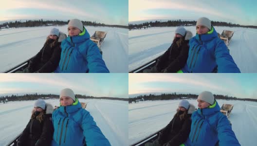 图:在冰雪覆盖的拉普兰，一对夫妇乘坐驯鹿雪橇旅游景点高清在线视频素材下载
