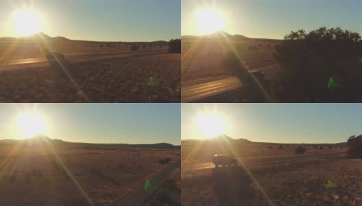 图片:金色的夏日夕阳下，一辆黑色SUV行驶在空旷的乡村道路上高清在线视频素材下载