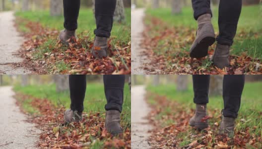 Young man in leather shoes is walking along a path with fallen leaves. Fall season. Outdoor city walk concept slow motion.高清在线视频素材下载