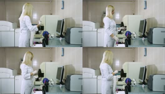 女性实验室助理在现代设备下分析血样。高清高清在线视频素材下载