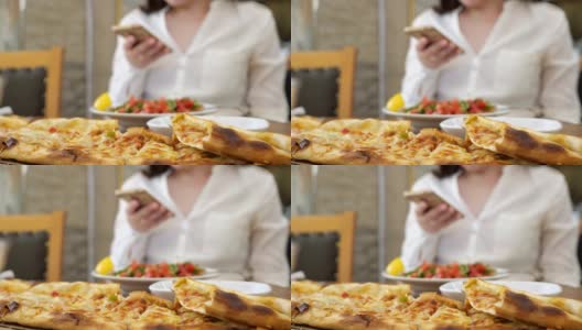 阿塞拜疆传统午餐与哈切布里和女人的电话在模糊。高清在线视频素材下载
