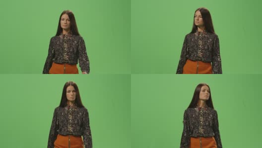 随意的黑发女人是走在一个模型的绿色屏幕在背景。高清在线视频素材下载