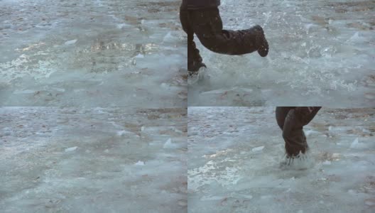 男孩在冰冷的水坑上奔跑，慢镜头250帧/秒高清在线视频素材下载