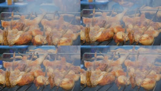 把整只鸡串在木棍上，放在烤架上烤制。街头食品泰国高清在线视频素材下载