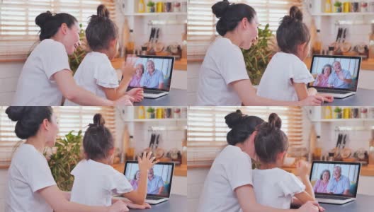 亚洲母亲和女儿在视频会议上与国外的祖父母家庭视频电话，在社会距离使用笔记本电脑和视频会议技术。社会电话会议高清在线视频素材下载