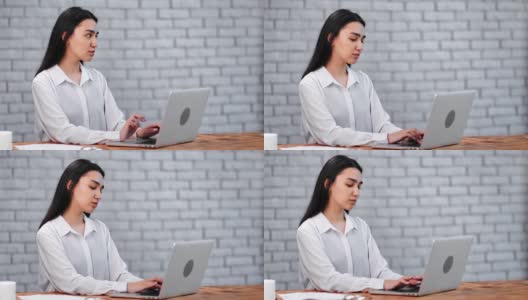 沉思的亚洲女商人在办公室用笔记本电脑聊天。由RED Raven 4k电影摄像机拍摄高清在线视频素材下载