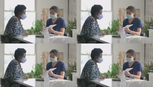 女医生与年长病人在门诊预约时戴口罩高清在线视频素材下载