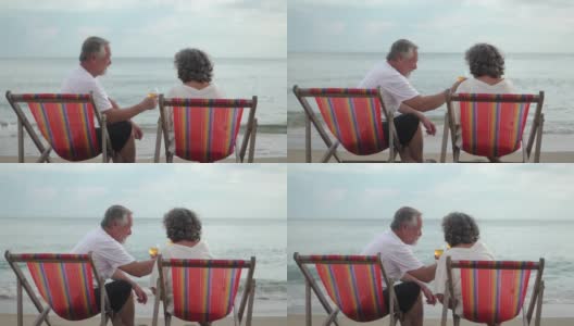 后视图老年人夫妇坐在海滩上欢呼香槟高清在线视频素材下载