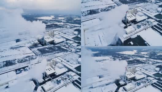 工厂下着雪，冬天里。我们可以看到一股烟从烟囱里冒出来，建筑物上覆盖着雪高清在线视频素材下载