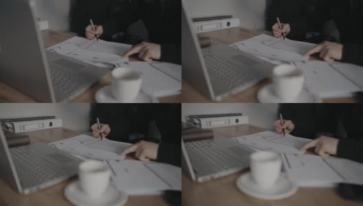 坐在笔记本电脑旁边的商人可以在合同文件上签字。商业伙伴。软焦点视频。高清在线视频素材下载