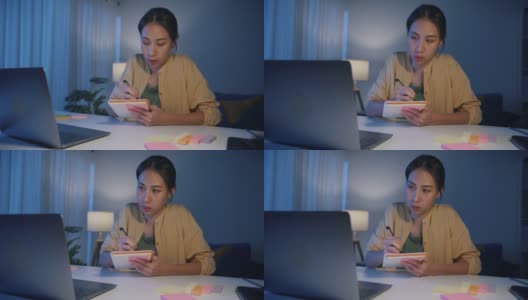 疲倦的年轻亚洲商业妇女在休闲工作笔记本电脑在客厅在家里。高清在线视频素材下载