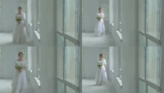 美丽的女孩穿着白色的衣服走过带花的窗口，慢镜头高清在线视频素材下载