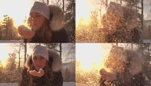 慢镜头:一个年轻女子在神奇的冬日夕阳下吹着闪闪发光的雪花高清在线视频素材下载