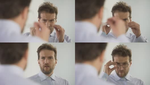 男人不满意他的眼镜和考虑视力矫正程序高清在线视频素材下载