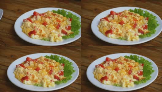餐厅木桌上的一盘格鲁吉亚煎蛋卷，配上番茄、奶酪和香草。高清在线视频素材下载