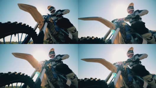 FMX骑手背对着太阳坐在摩托车上高清在线视频素材下载