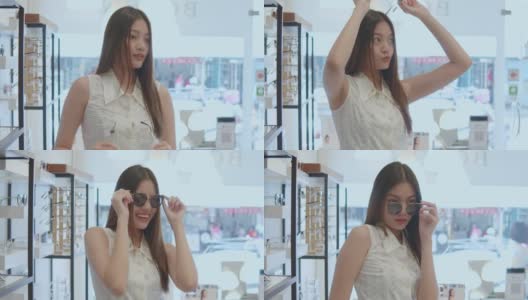 年轻的亚洲女人在光学商店挑选和试穿眼镜，慢镜头高清在线视频素材下载