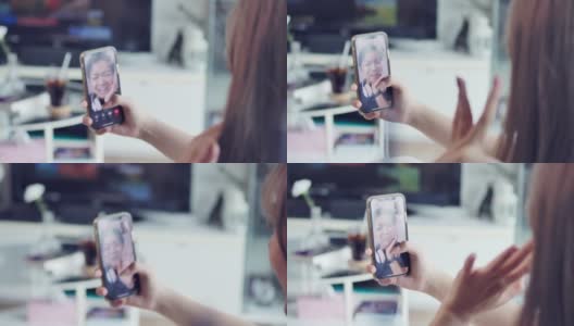 一名亚洲少女在隔离期间用智能手机与朋友视频通话。高清在线视频素材下载