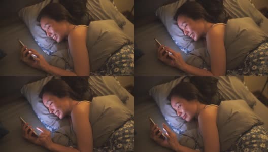 一名亚洲女性在床上使用智能手机高清在线视频素材下载