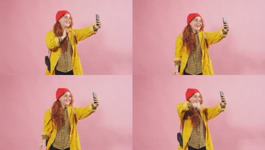 一名身穿黄色斗篷的红发女孩在Skype上与朋友交流高清在线视频素材下载