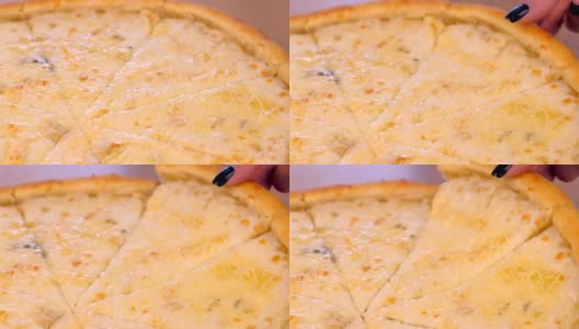 女人拿着一片披萨玛格丽塔与不同类型的奶酪在木板上的特写视图。高清在线视频素材下载