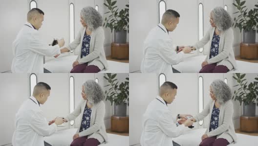医生在老年女性病人身上放置血压仪高清在线视频素材下载