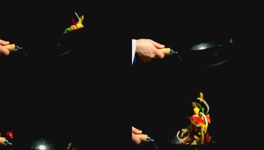 厨师在炒锅里翻炒蔬菜，在黑色背景上的侧视图高清在线视频素材下载