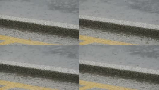 几滴大雨落在沥青上。热带降雨高清在线视频素材下载