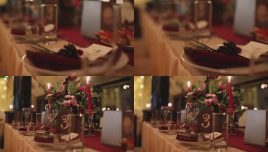 圣诞婚礼宴会厅内部细节装饰和餐桌设置在餐厅。冬季装饰的球根花环，蜡烛，鲜花，球果和冷杉树枝高清在线视频素材下载