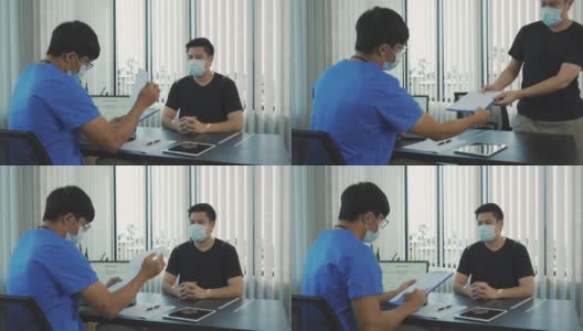 在疫情期间，医生们戴着口罩向患者解释治疗方法。高清在线视频素材下载