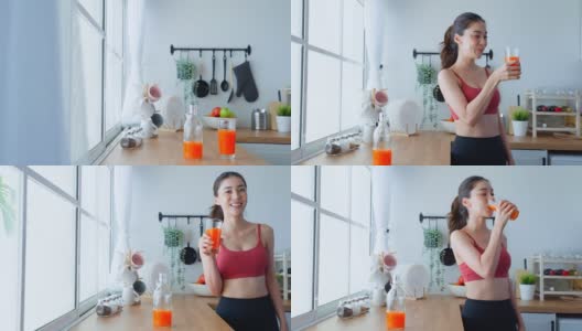亚洲美女肖像拿着橙汁看着相机。迷人的运动女孩穿着运动服端着一杯水，在家锻炼后享受健康饮食高清在线视频素材下载