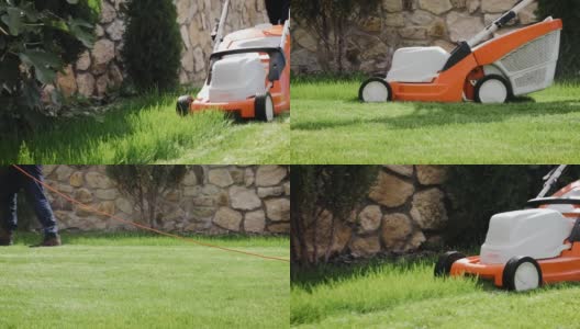 一个男人在后院用电动割草机割草的特写镜头高清在线视频素材下载