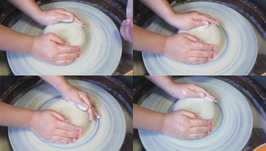 陶工大师的手在陶工轮上给学生的粘土坯增加水分高清在线视频素材下载