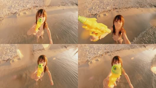 小女孩玩水枪，向镜头喷水高清在线视频素材下载
