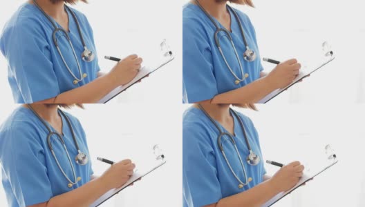 女医生用蓝色制服在写字板上写字高清在线视频素材下载