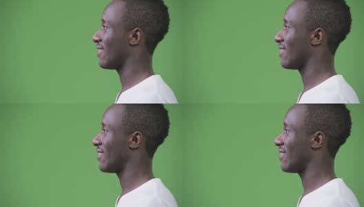 侧面视图的年轻快乐的非洲人对绿色的背景高清在线视频素材下载