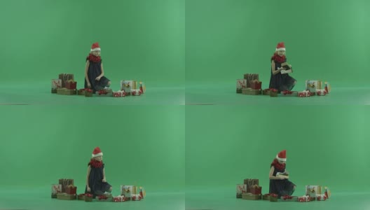 可爱的小女孩在圣诞帽得到了一个漂亮的圣诞礼物，色度键的背景高清在线视频素材下载