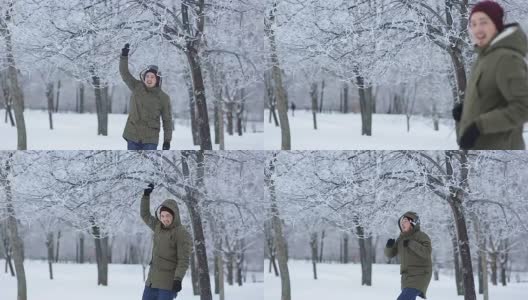 一名男子从公园的树枝上扔下雪高清在线视频素材下载